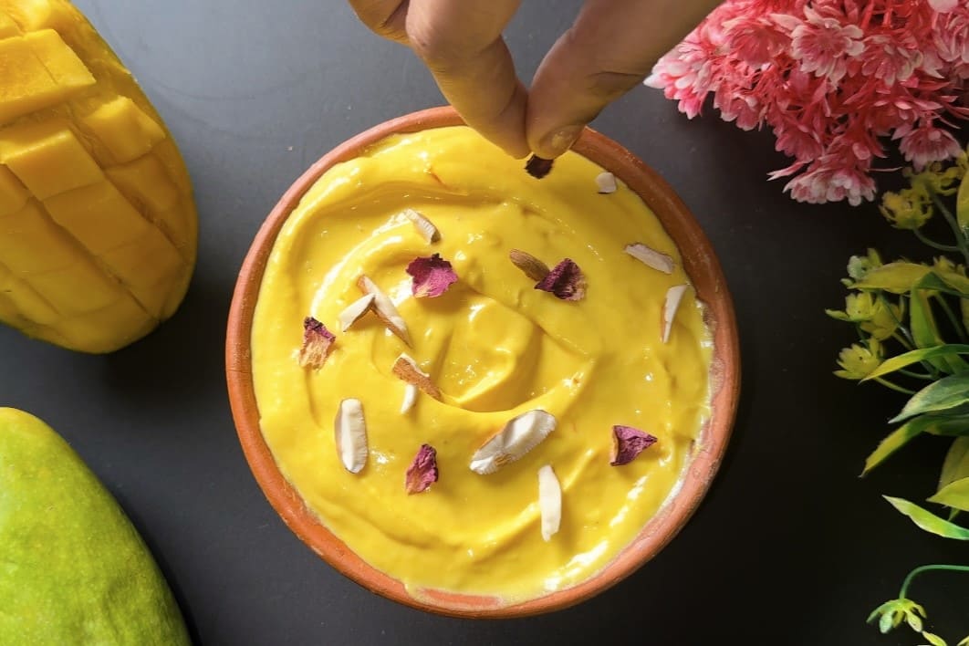 Mango Shrikhand garnished with chopped nuts, saffron