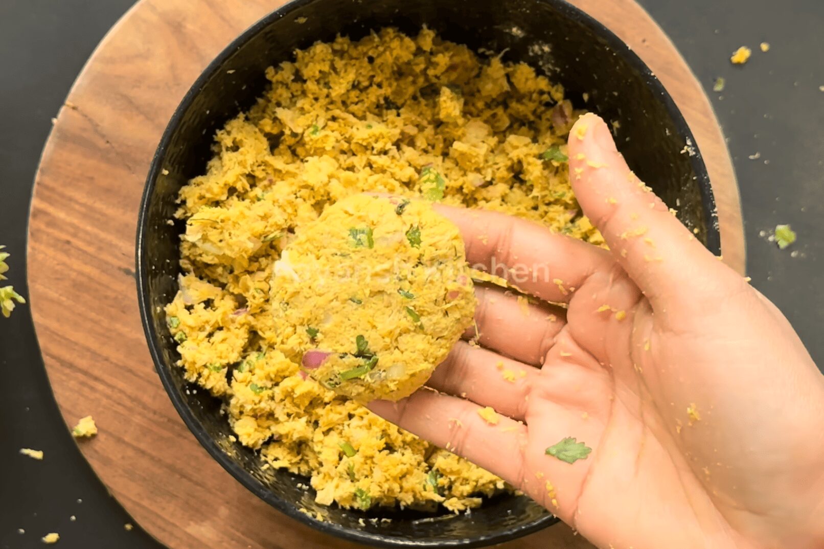 Shaping raw soya chunks veg kebab dough ball into a round flat patty between palms