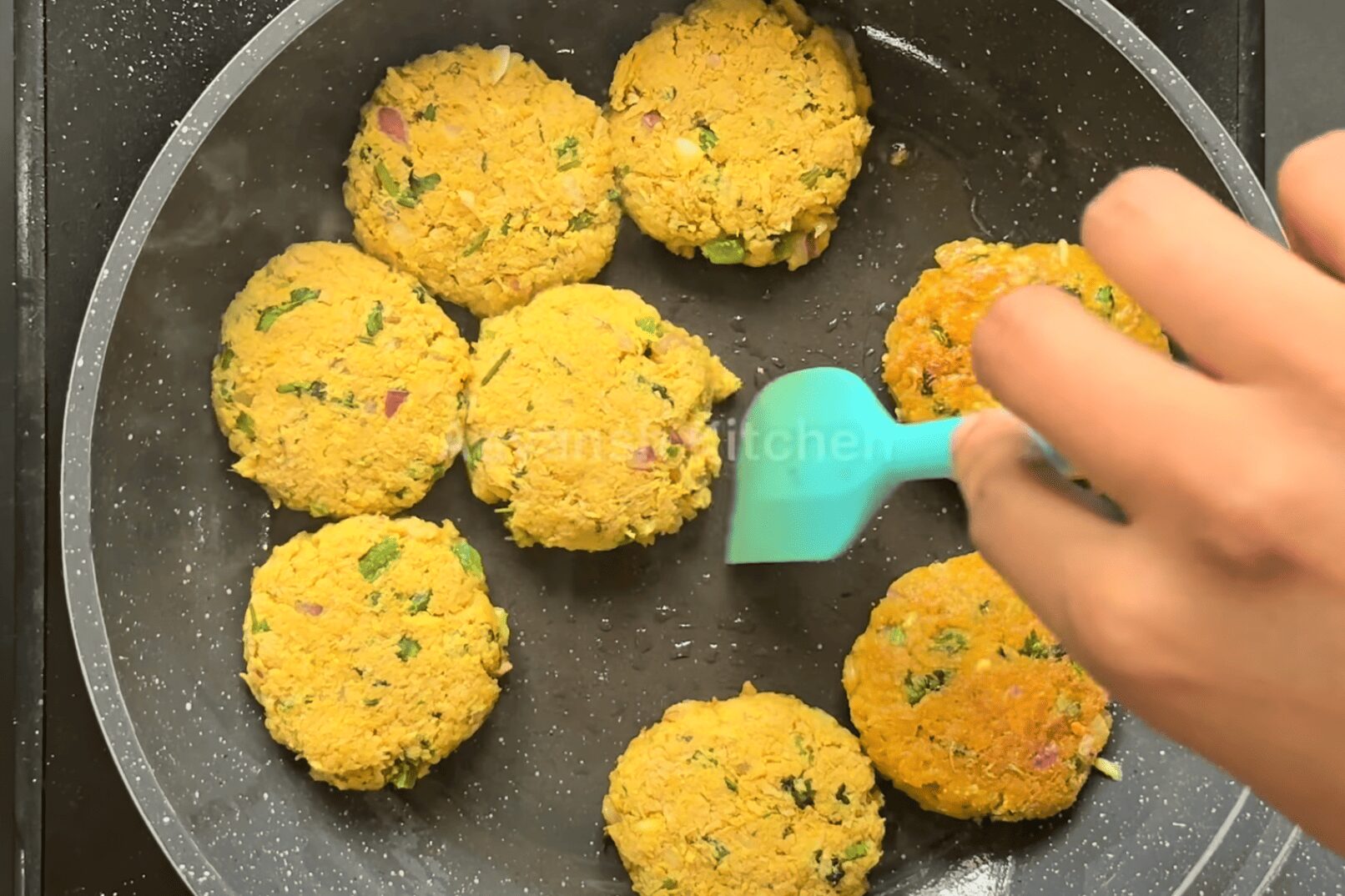 Shallow frying soya kebabs in a pan with ghee until golden brown